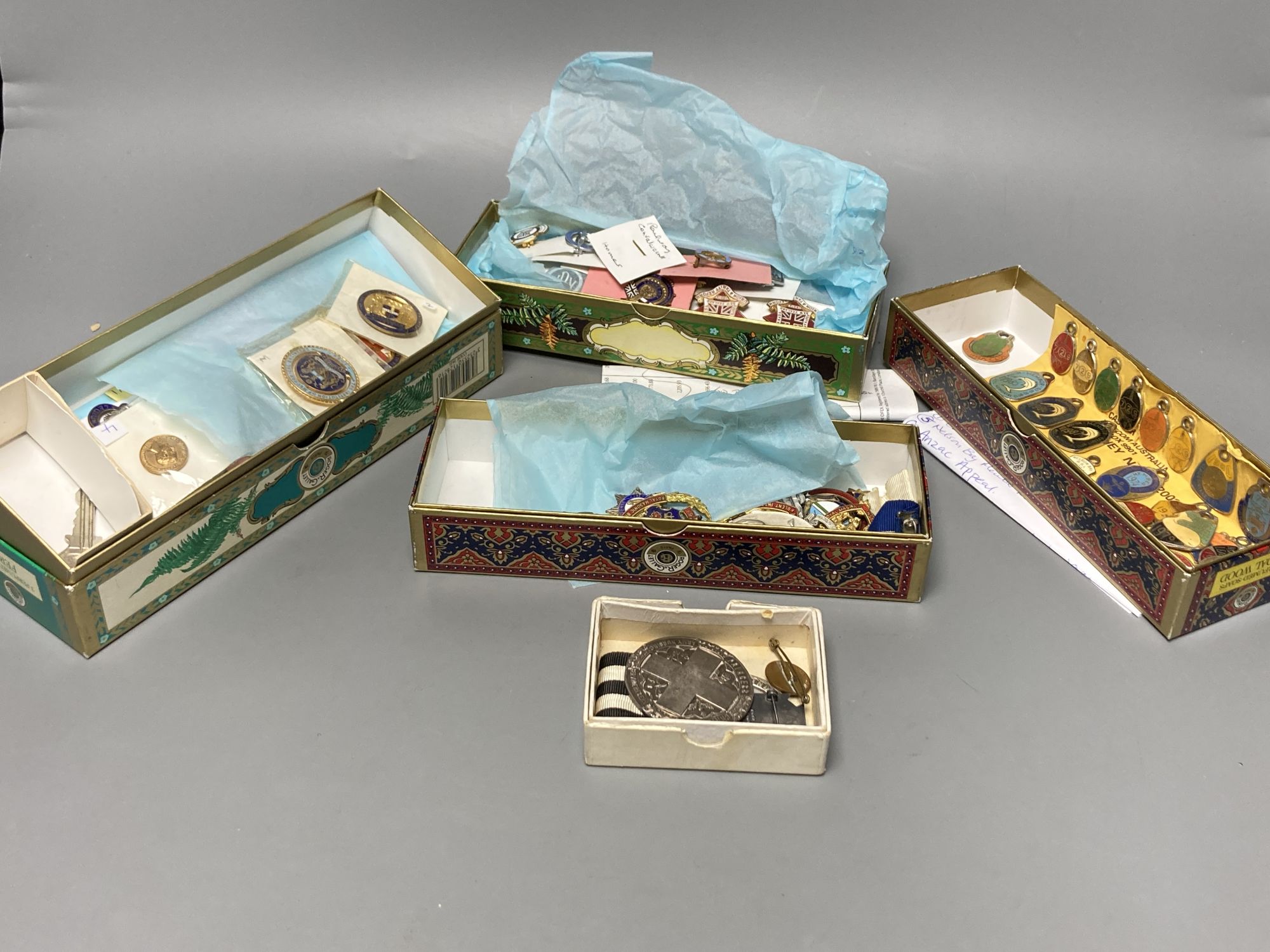 A collection of assorted enamel badges and nursing badges